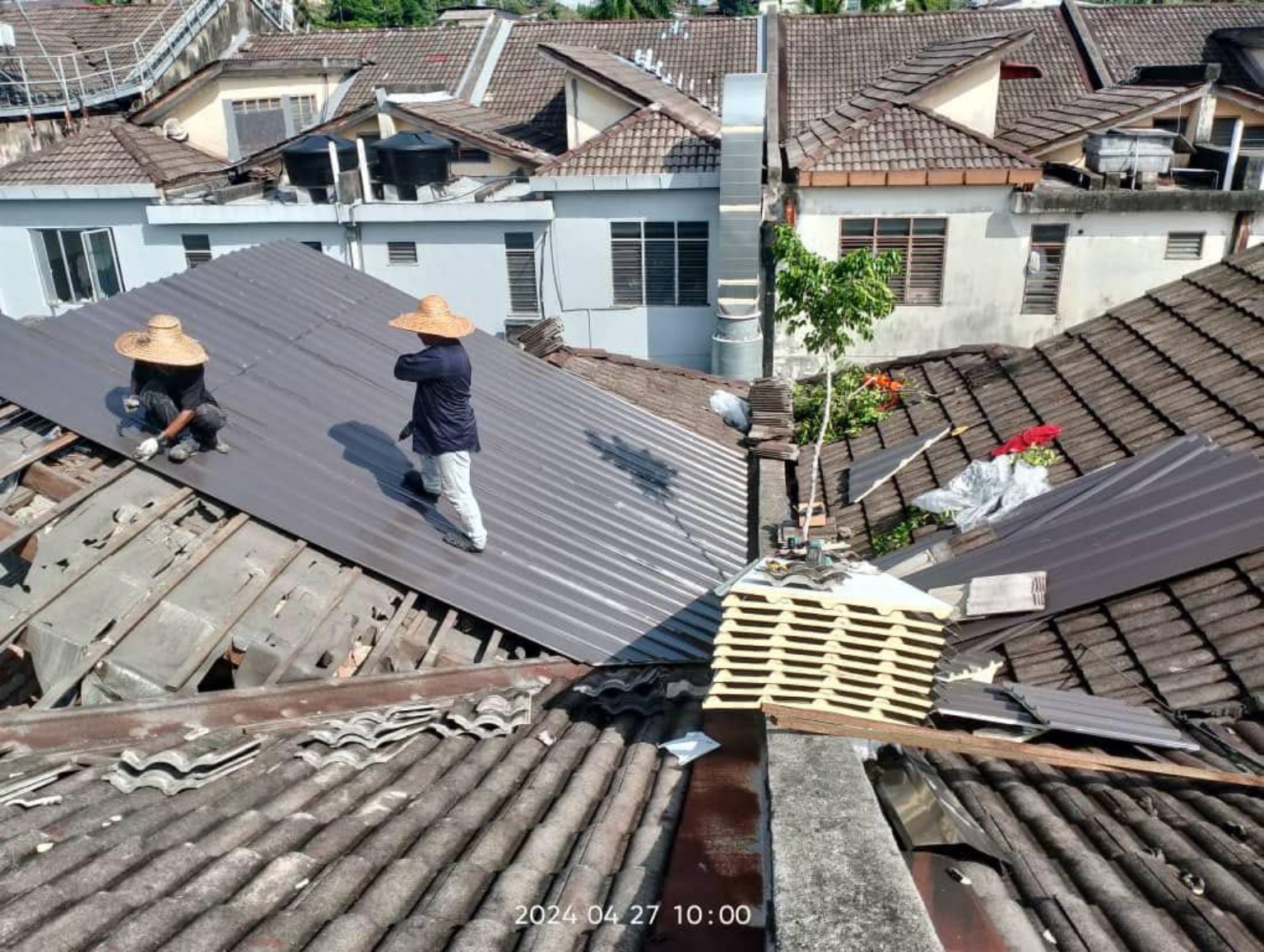 Metal roof sheet replacement in progress.